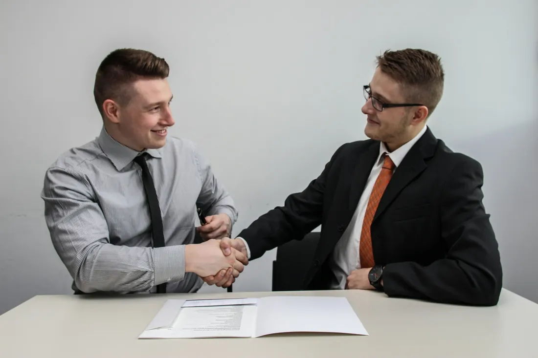 Two business professionals smiling and shaking hands